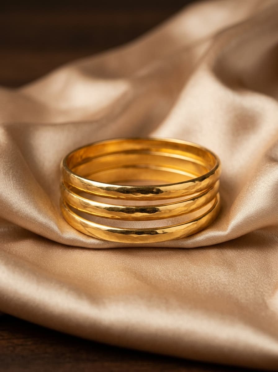 Elegant polished gold bangles on silk fabric